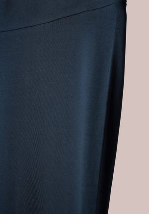 Middengrijze stof, gladde textuur, rekbaar materiaal, heeft een hoge tailleband en lijkt deel uit te maken van een kledingstuk zoals legging of yogabroek.