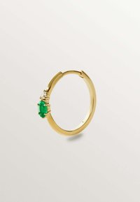 El pendiente de aro dorado presenta una gema ovalada verde y un pequeño acento de piedra clara, con una textura suave y un diseño de cierre articulado.