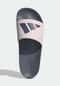 Sandały klapki Adidas z teksturowanym różowym syntetycznym paskiem z ciemnoniebieskimi akcentami i ciemnoniebieską gumową podeszwą.