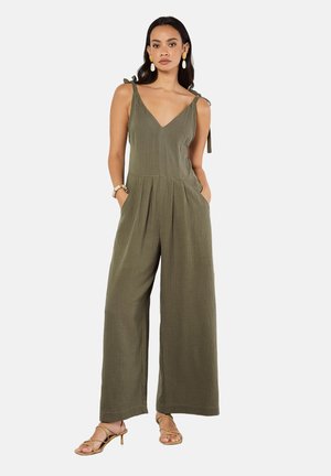 Olive green jumpsuit with wide legs, V-neckline, and tie straps. Lightweight fabric with a textured finish. Includes side pockets.