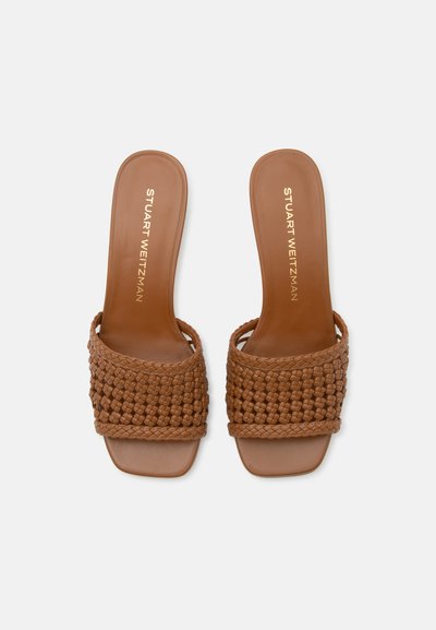 Paire de sandales en cuir marron à enfiler avec larges brides tissées et bout carré, semelle intérieure matelassée portant l’étiquette Stuart Weitzman.