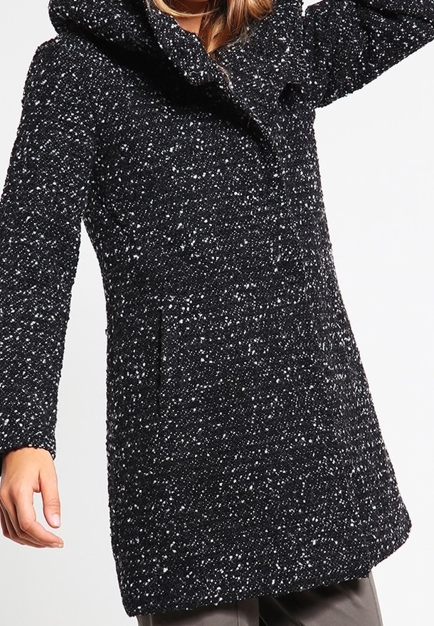 Cappotto a pois bianco e nero con cappuccio, maniche lunghe, tasche frontali e un tessuto testurizzato. Design classico con vestibilità su misura.