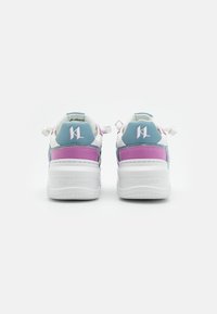 White sneakers with teal and pink accents, textured materials, chunky sole, and prominent "KL" logo on the heel.