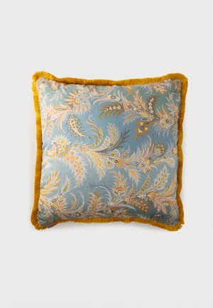 Square throw pillow with blue background, intricate floral paisley patterns in gold and beige, and mustard yellow fringe trim.