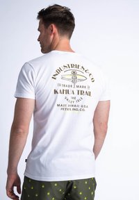 Bílý bavlněný tričko s grafickým potiskem na zadní straně s designem surfovacího prkna a textem. Krátké rukávy a kulatý výstřih.