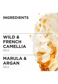 Productlabel met ingrediënten: "Wilde & Franse Camelia Oliën" en "Marula & Argan Oliën." Achtergrond met draaiende gouden vloeistof en witte bloemblaadjes.