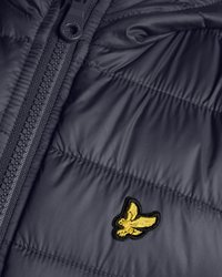 Temno modra puffer jakna s horizontalnim šivom, zadrgo in majhnim zlatim vezenim logotipom orla na sprednjem delu.