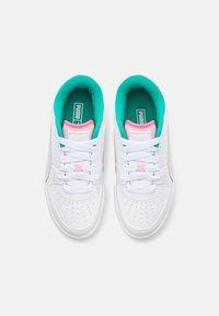 Baskets blanches avec des accents turquoise et rose, présentant une tige en cuir lisse, un bout perforé pour la respirabilité, et des lacets plats blancs.