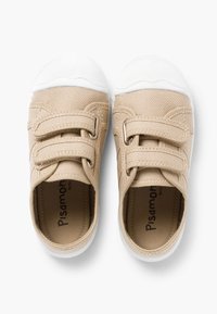 Pantofi din pânză bej cu talpă din cauciuc albă, având două curele Velcro și un material texturat în partea superioară. În interior sunt etichetați cu "Pisamonas."