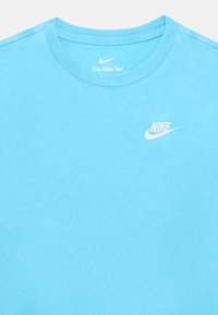 Ljust blå bomulls t-shirt med rund hals, prytt med en liten vit Nike-logga på bröstet och en jämn, slät textur.