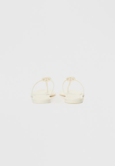 Flat sandals in off-white with thin straps, a smooth texture, and a gold-tone accent on the strap. Square toe design.