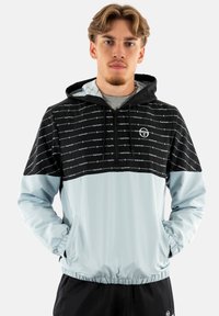 Giacca con cappuccio blu chiaro e nera, con zip frontale, polsini elasticizzati e un motivo grafico nella parte superiore.