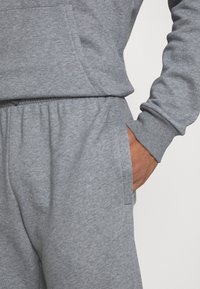 Grau Sweatshirt- und Sweatpants-Set, mit einem glatten Stofftextur, seitlichen Taschen und gerippten Bündchen. Lässiges Design, bequemer Schnitt.