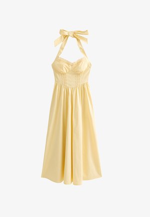 Vestido amarillo pálido con cuello halter, adorno de encaje en el busto, cintura ajustada y falda midi fluida.