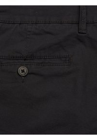 Svarta byxor med en slät yta, utrustade med en framficka och knappstängning. Sömmar synliga längs kanterna.