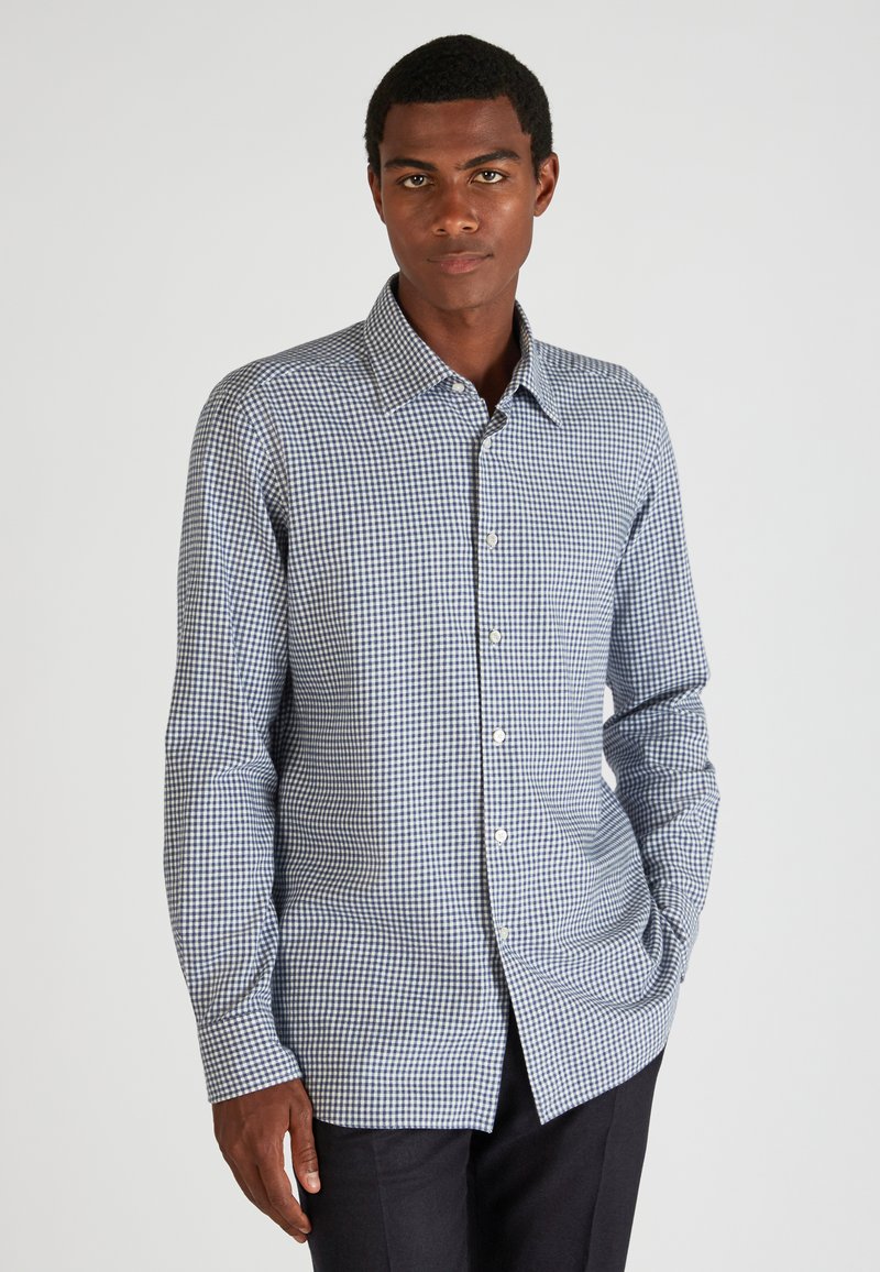 Camicia a quadri blu e bianca in tessuto leggero, con colletto classico e maniche lunghe con orlo dritto.