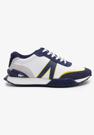 Witte sneaker met marineblauwe en gele accenten, uitgerust met een gestructureerde zool, een gladde bovenkant en vetersluiting. Lacoste-logo aan de zijkant.