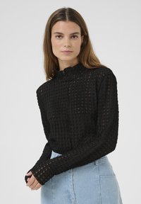Sort langærmet top med et struktureret design, der har lodrette striber og en høj halsudskæring. Let gennemsigtigt materiale, tætsiddende ærmer.