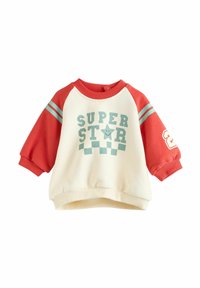 Hvid sweater med røde raglanærmer. Har grafikken "SUPER STAR", teal striber og et ternet mønster i bunden.