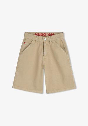 Shorts beige clair en tissu texturé, avec poches avant, fermeture bouton et une étiquette brodée rouge sur la ceinture.