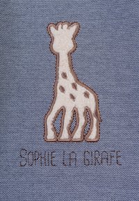 Prägedruck eines Giraffenlogos in Beige mit braunen Flecken auf einem strukturierten grauen Stoffhintergrund. Darunter steht der Text "Sophie la Girafe."