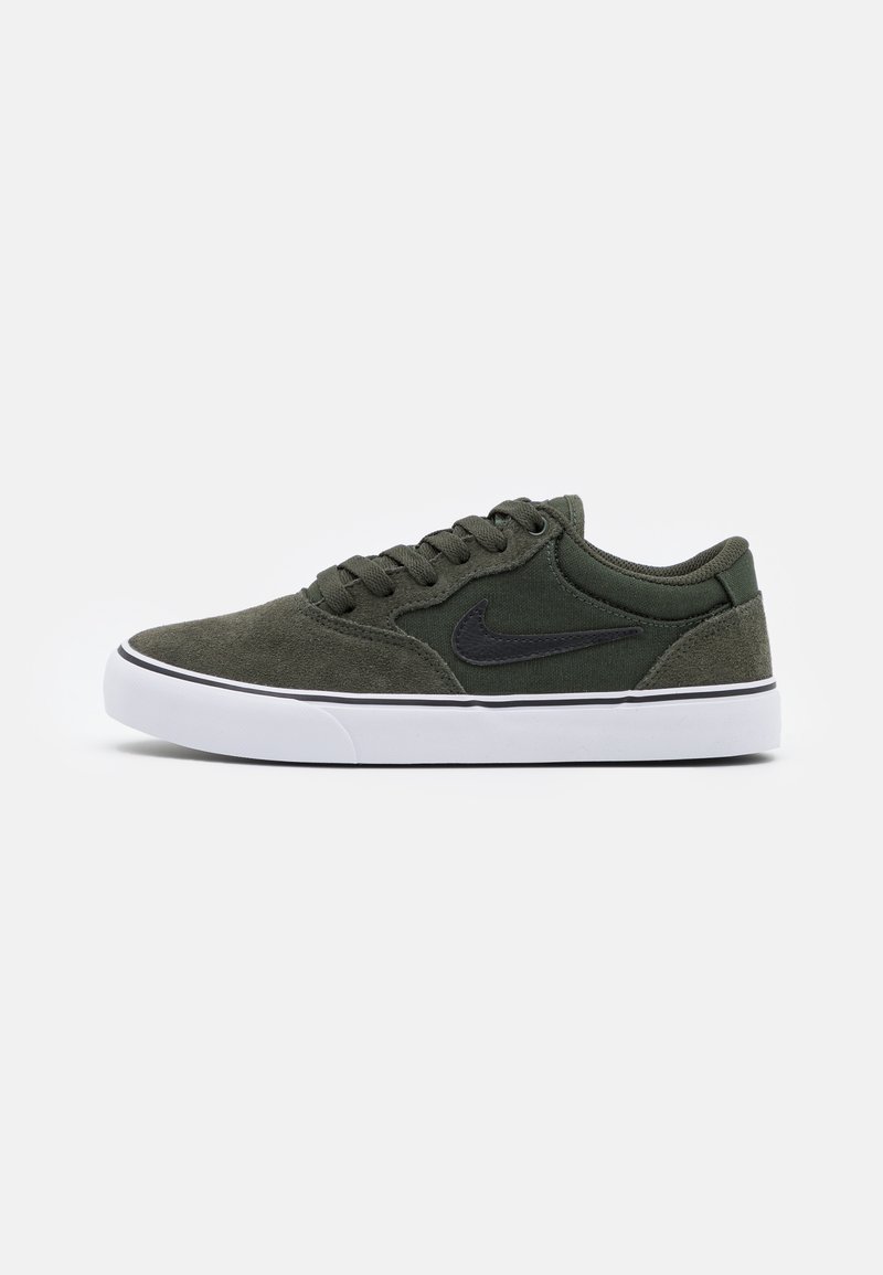 Grønne ruskinds sneakers med sorte detaljer og hvid gummisål; har snørebånd, polstret krave og et logo på siden. Glat tekstur, lav-top design.