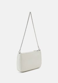 Sac à main rectangulaire blanc avec bandoulière chaîne argentée et fermeture éclair sur le dessus, présenté sur un fond uni gris clair.