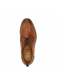 Bruine leren dresschoen met ronde neus, zwarte veters en subtiele stiksels. Voorzien van een gemarkeerde binnenzool en een trekband aan de hiel.