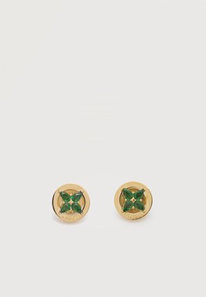 Par de pendientes de botón redondos de oro con cuatro pétalos de piedra verde y "GUESS" grabado en el borde exterior.