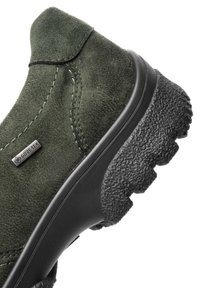 Dunkelgrüner Wildleder-Wanderschuh mit GORE-TEX-Label und dicker, strukturiertem schwarzen Gummisohle mit tiefen Profilen für besseren Halt.