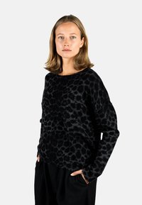 Schwarzes Langarmpullover mit strukturiertem Leopardenmuster, aus weichem Material gefertigt; Rundhalsausschnitt und lässiger Schnitt.