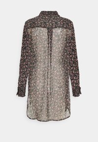 Svart genomskinlig blus med rosa blommönster, långa ärmar, krage och rynkade manschetter. Har en knytning baktill.