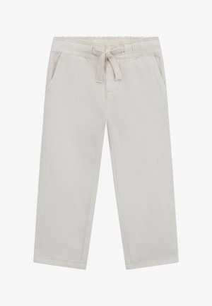 Světle béžové tepláky vyrobené z měkkého materiálu, s elastickým pasem a nastavitelným šňůrkovým stahováním, bočními kapsami a rovnými nohavicemi.