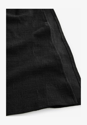 Černá texturovaná tkanina s jemným skládacím vzorem. Okraje vykazují švy a tkanina má měkký, ale strukturovaný vzhled.