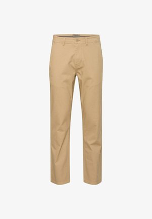 Chinos en coton beige avec une coupe droite, passants de ceinture, fermeture à bouton à l'avant et deux poches latérales. Texture lisse avec peu de plis.
