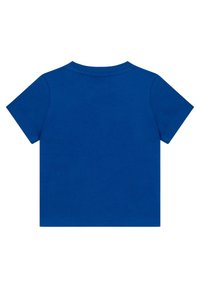 Kratší modré bavlněné tričko s kulatým výstřihem. Hladká textura, žádné viditelné vzory ani logo, jednoduše navržená zadní strana.
