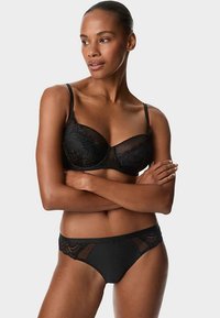Sort bh med blomsterblonde, bøjleunderstøttelse og justerbare stropper, kombineret med matchende sort undertøj med netdetaljer.