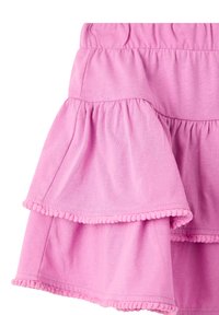 Gonna di cotone rosa con volant a strati, caratterizzata da un bordo in pompon lungo l'orlo. Tessuto morbido e vita elasticizzata per il massimo comfort.