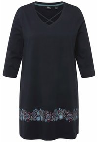 Schwarze Tunika mit V-Ausschnitt und Kreuzdetails. Verfügt über dreiviertel Ärmel und ein florales Stickmuster in Blau, Rot und Grau am Saum.