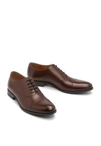 Pantofi eleganți din piele maro cu un finisaj neted, sistem de închidere cu șireturi ascunse și design cu vârful acoperit. Caracterizează o siluetă elegantă și un toc jos.