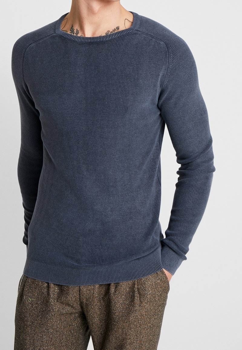 Maglione a costine blu navy con maniche lunghe e scollatura a girocollo, caratterizzato da una finitura textured e un silhouette aderente.