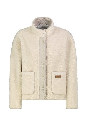 Cream-colored sherpa fleece jacket with high collar, snap button front, and two large front pockets, one with a small leather brand patch.