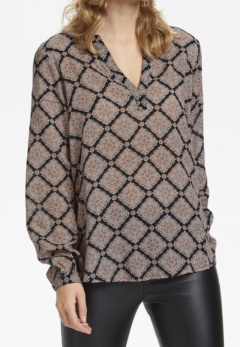 Blusa a maniche lunghe in tessuto nero con un motivo geometrico arancione e blu, con scollatura a V e polsini elasticizzati.