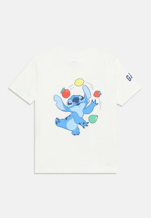 Wit shirt met korte mouwen met een blauwe figuur die jongleert met een citroen, tomaat, aardbei en peer, met "GAP" op de mouw.