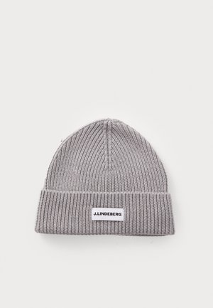 Bonnet gris tricoté avec une texture en côte, revers replié, et une étiquette rectangulaire blanche affichant "J.LINDEBERG". Design compact et structuré.