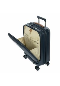 Valigia a righe in nylon blu con manico telescopico, quattro ruote e apertura con zip che rivela un interno crema con tasche organizzative.