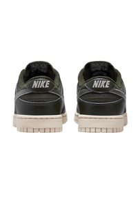 Nike Sneaker mit oberem Material aus dunkelgrünem Wildleder und Leder, hellgrauen Akzenten und einer cremefarbenen Gummisohle. Branding an der Ferse.
