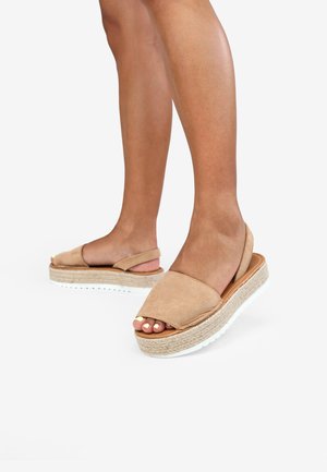 Sandalias de plataforma de ante color beige con diseño de punta abierta, correa trasera y detalles de yute trenzado, que cuentan con una suela de goma blanca.