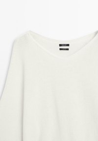 Lightweight, knitted white cotton sweater with a relaxed fit and a wide neckline; features a label with branding inside the neck area.