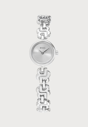 Zilverkleurig rond analoog polshorloge met BOSS-logo en een decoratieve metalen schakelarmband op een lichte achtergrond.